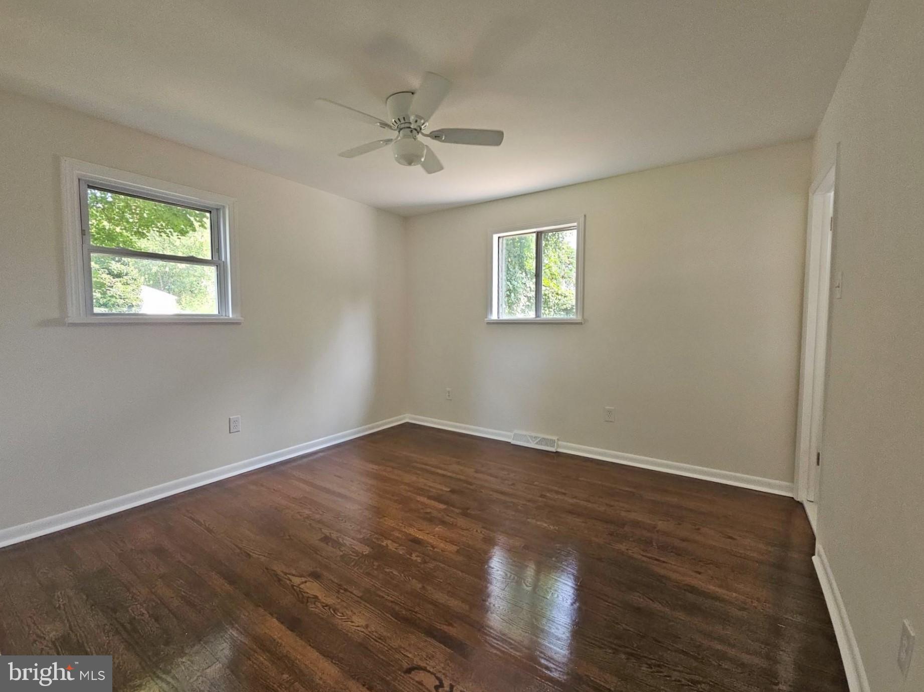 82 Harvard Road Pennsville, NJ 08070 - Photo 13 of 18 a view of an empty room with wooden floor and a window