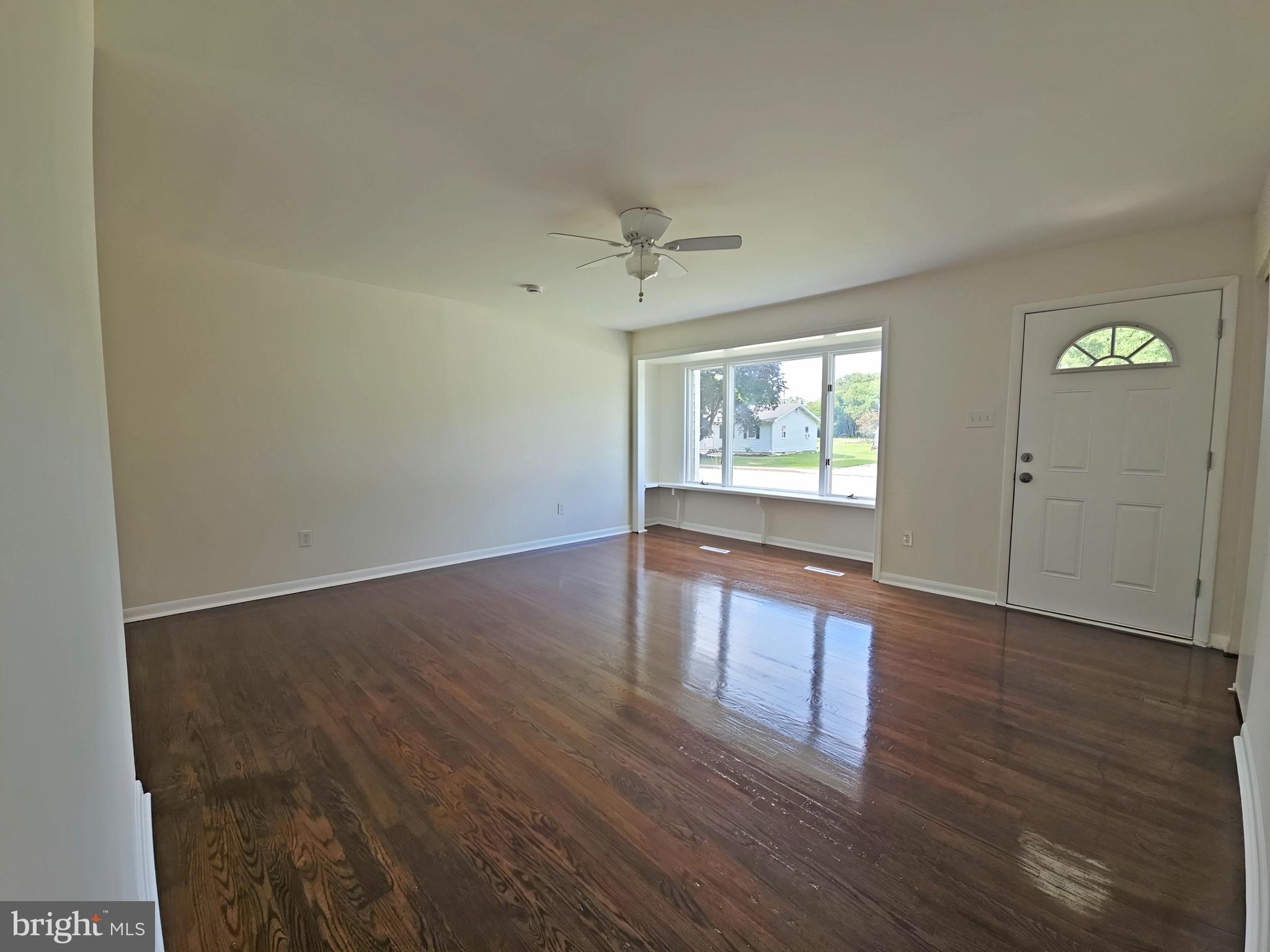 82 Harvard Road Pennsville, NJ 08070 - Photo 4 of 18 an empty room with wooden floor and windows