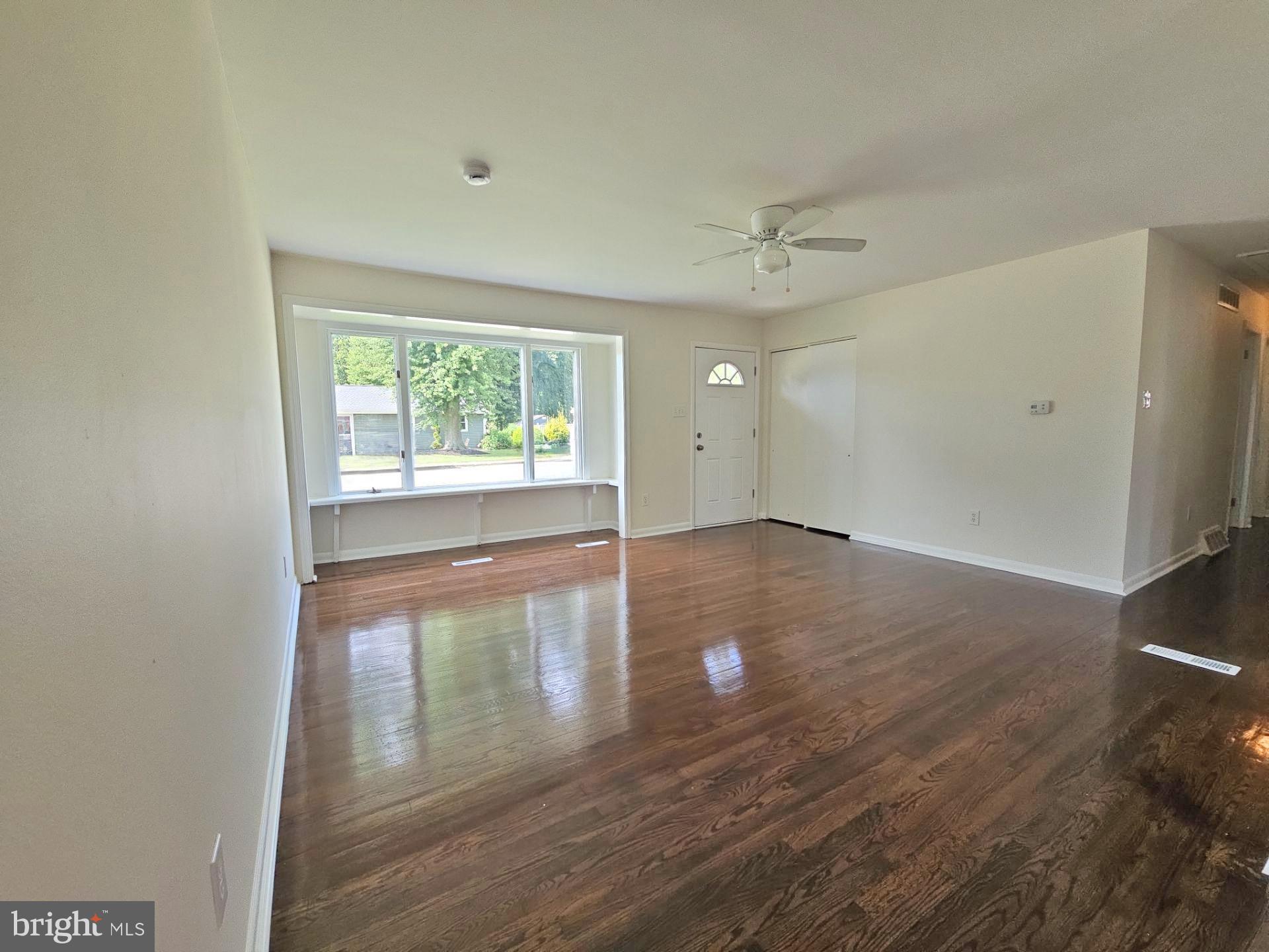 82 Harvard Road Pennsville, NJ 08070 - Photo 5 of 18 an empty room with wooden floor and windows