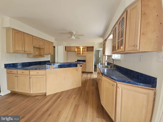 a kitchen with granite countertop wooden floors and white stainless steel appliances