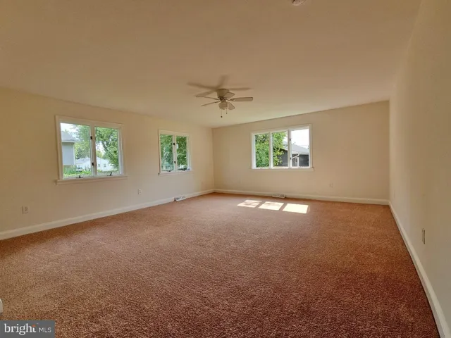an empty room with a window and a ceiling fan