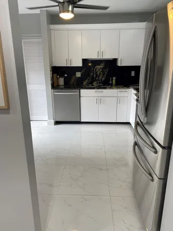 a kitchen with a sink a refrigerator and cabinets