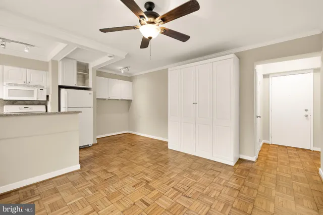 a kitchen with white cabinets and refrigerator