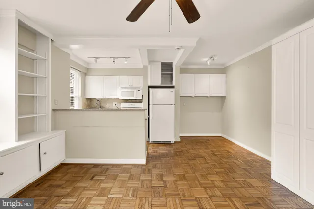 a kitchen with a refrigerator and white cabinets