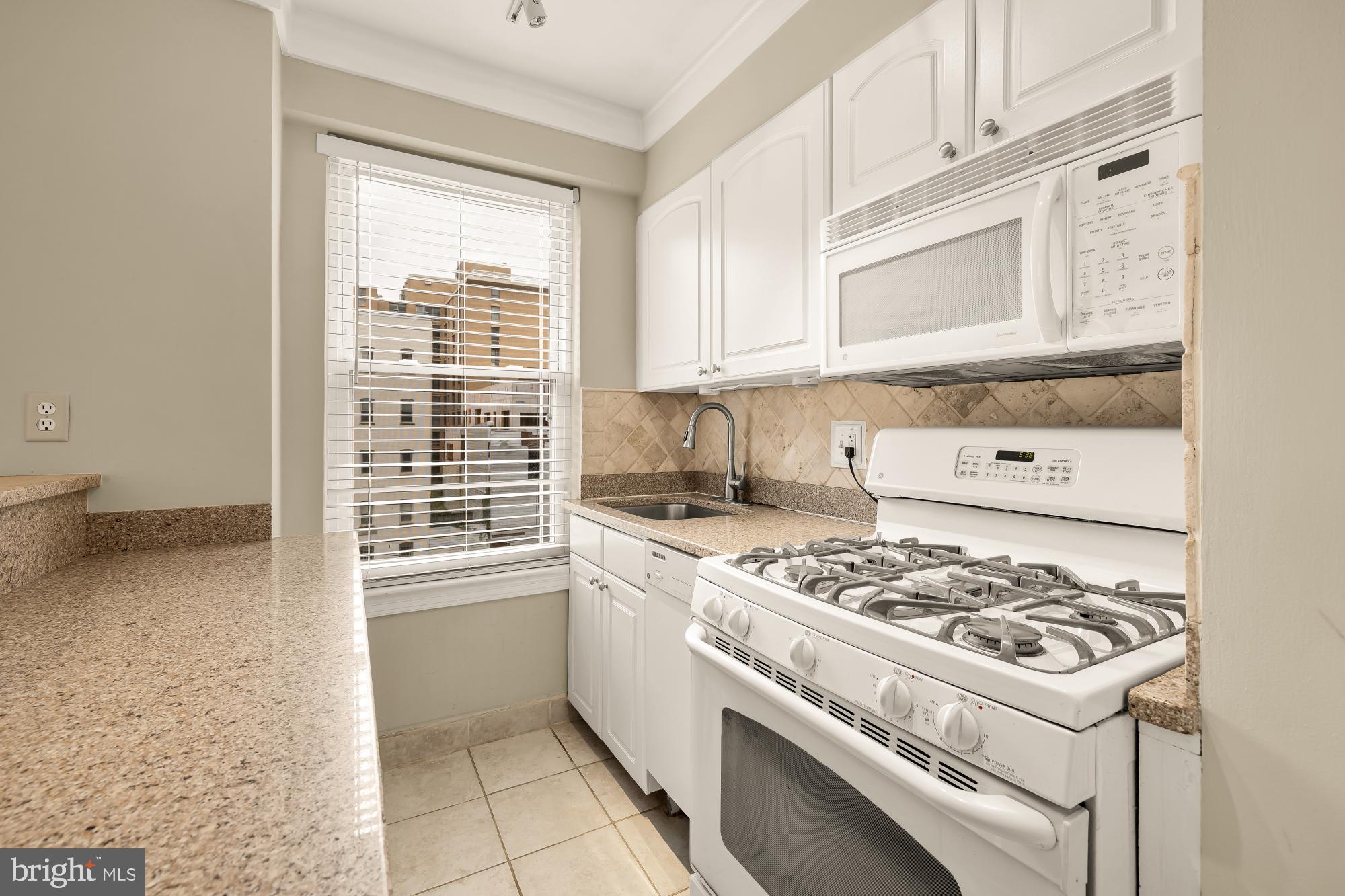 2130 N Street Northwest, Unit 407 Washington, DC 20037 - Photo 21 of 31 a kitchen with a stove a sink and a cabinets