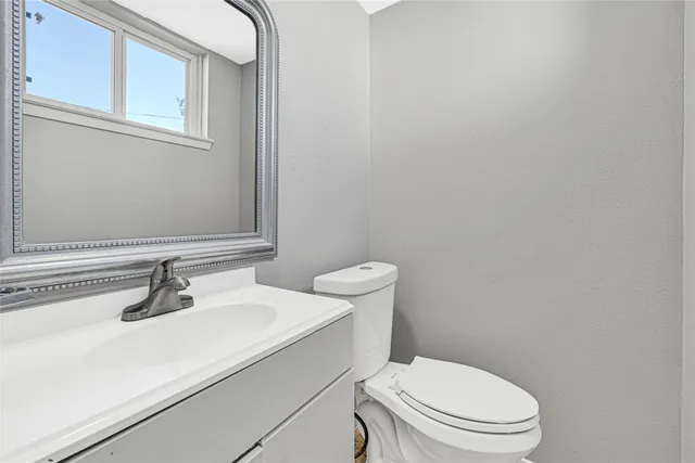 a bathroom with a sink a toilet and mirror