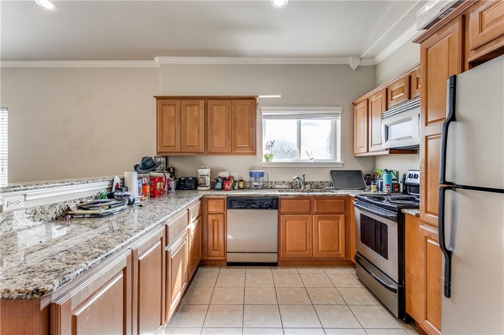 3011 Speedway, Unit 6 Austin, TX 78705 - Photo 6 of 11 a kitchen with stainless steel appliances granite countertop a sink stove refrigerator and cabinets