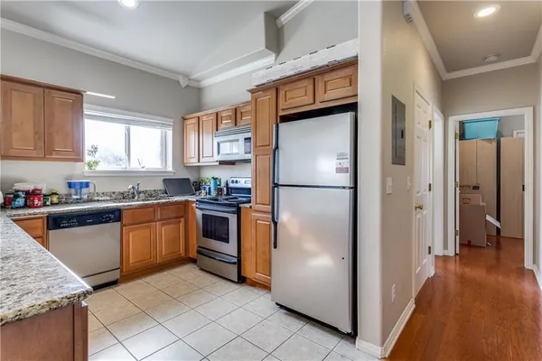 a kitchen with granite countertop stainless steel appliances a refrigerator a sink a counter top space and cabinets