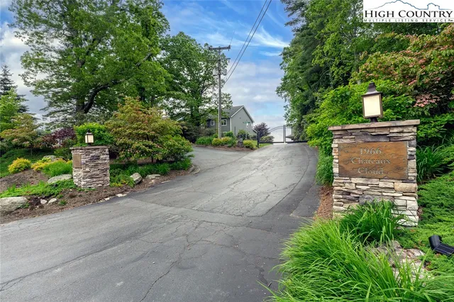 a pathway of a house with a yard and table and chairs