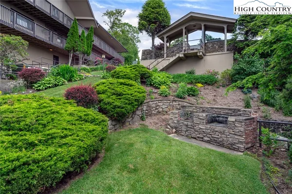 a view of a house with a big yard plants and large trees