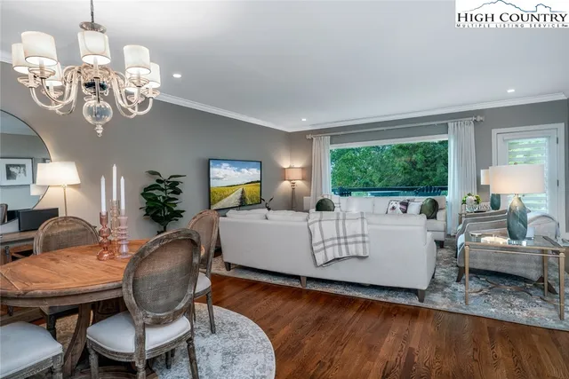a living room with furniture chandelier and a window