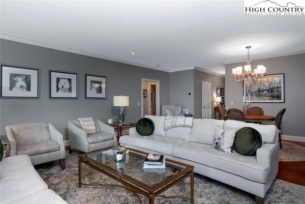a living room with furniture a lamp and a chandelier