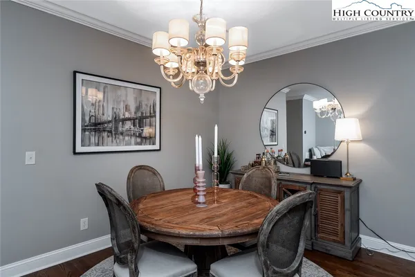 a dining room with furniture a chandelier and wooden floor