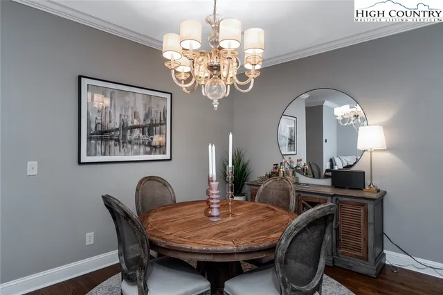 a dining room with furniture a chandelier and wooden floor