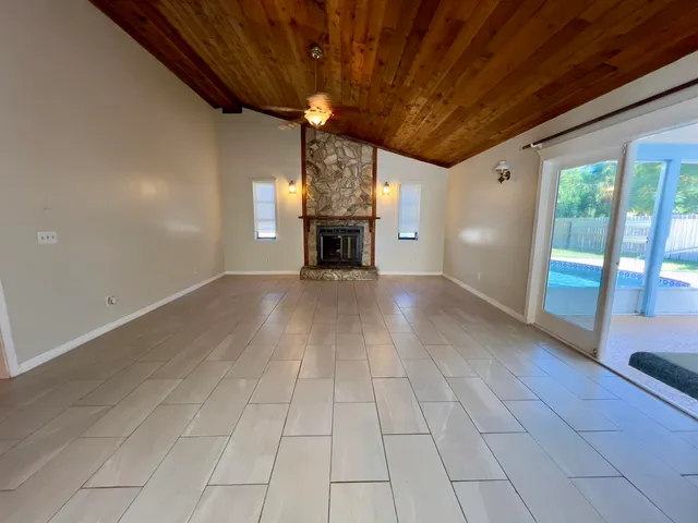 a view of an empty room with a fireplace and a chandelier
