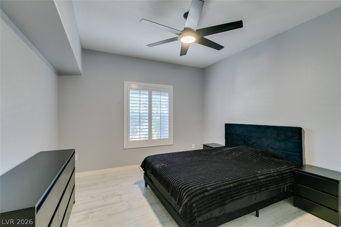 7255 West Sunset Road, Unit 1103 Las Vegas, NV 89113 - Photo 3 of 35 An inviting bedroom with light wood flooring and a modern ceiling fan for comfort.