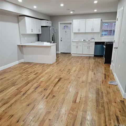 a large kitchen with kitchen island a sink a stove and a refrigerator