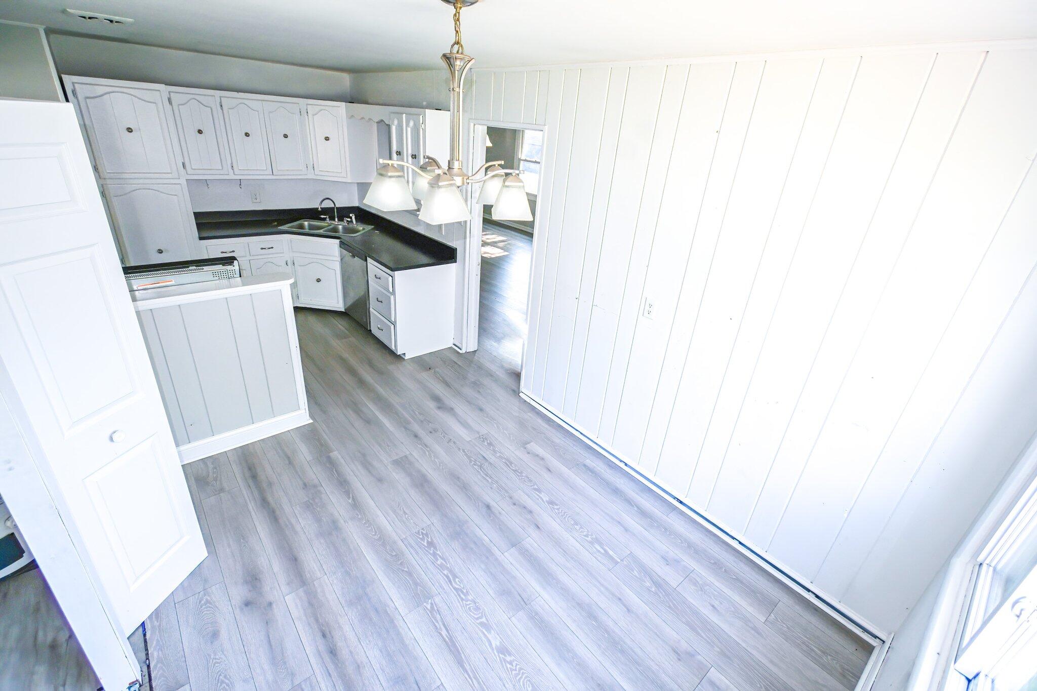 7828 Chestnut Avenue Hammond, IN 46324 - Photo 3 of 23 a kitchen with a sink a refrigerator a stove and white cabinets with wooden floor