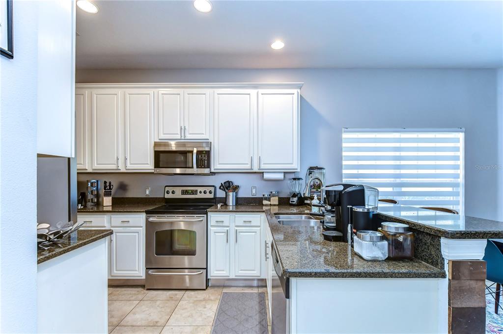 8507 Sandpiper Ridge Avenue Tampa, FL 33647 - Photo 12 of 48 a kitchen with stainless steel appliances granite countertop a stove a sink and a microwave