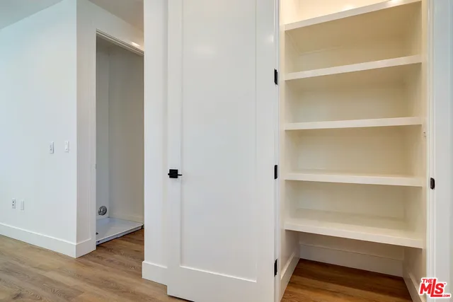a view of walk in closet with empty racks