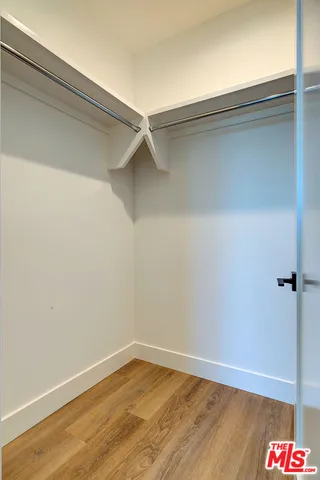 an empty room with wooden floor and closet area