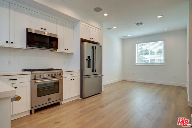 a kitchen with stainless steel appliances a stove microwave and sink