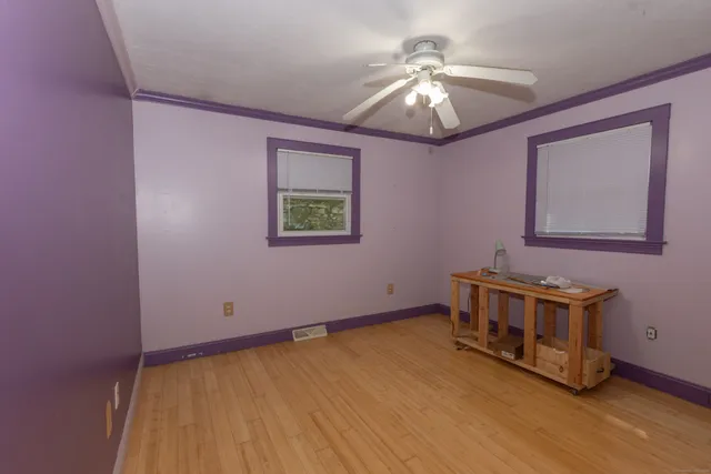 a room with a bed and a chandelier fan