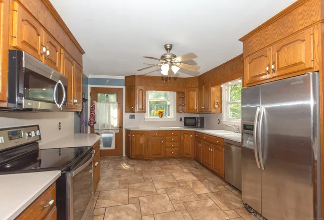 a large kitchen with stainless steel appliances granite countertop a sink stove and refrigerator