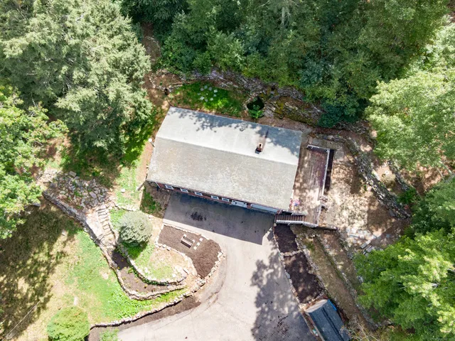 an aerial view of a house with a yard and large trees