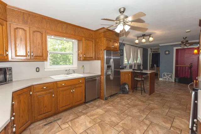 a kitchen with stainless steel appliances granite countertop a sink refrigerator and cabinets
