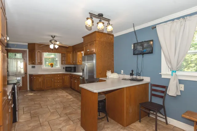 a large kitchen with a sink a counter space and stainless steel appliances