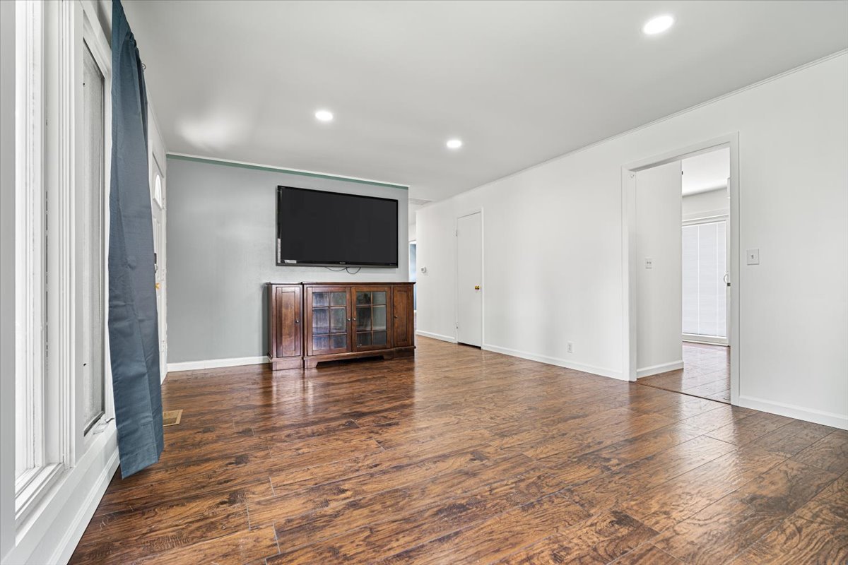 396 North Sherman Street El Paso, IL 61738 - Photo 5 of 29 an empty room with wooden floor and a flat screen tv