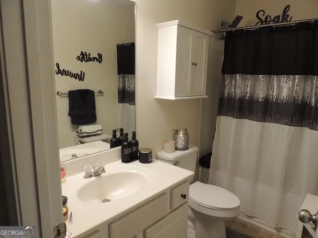 a bathroom with a sink toilet and mirror