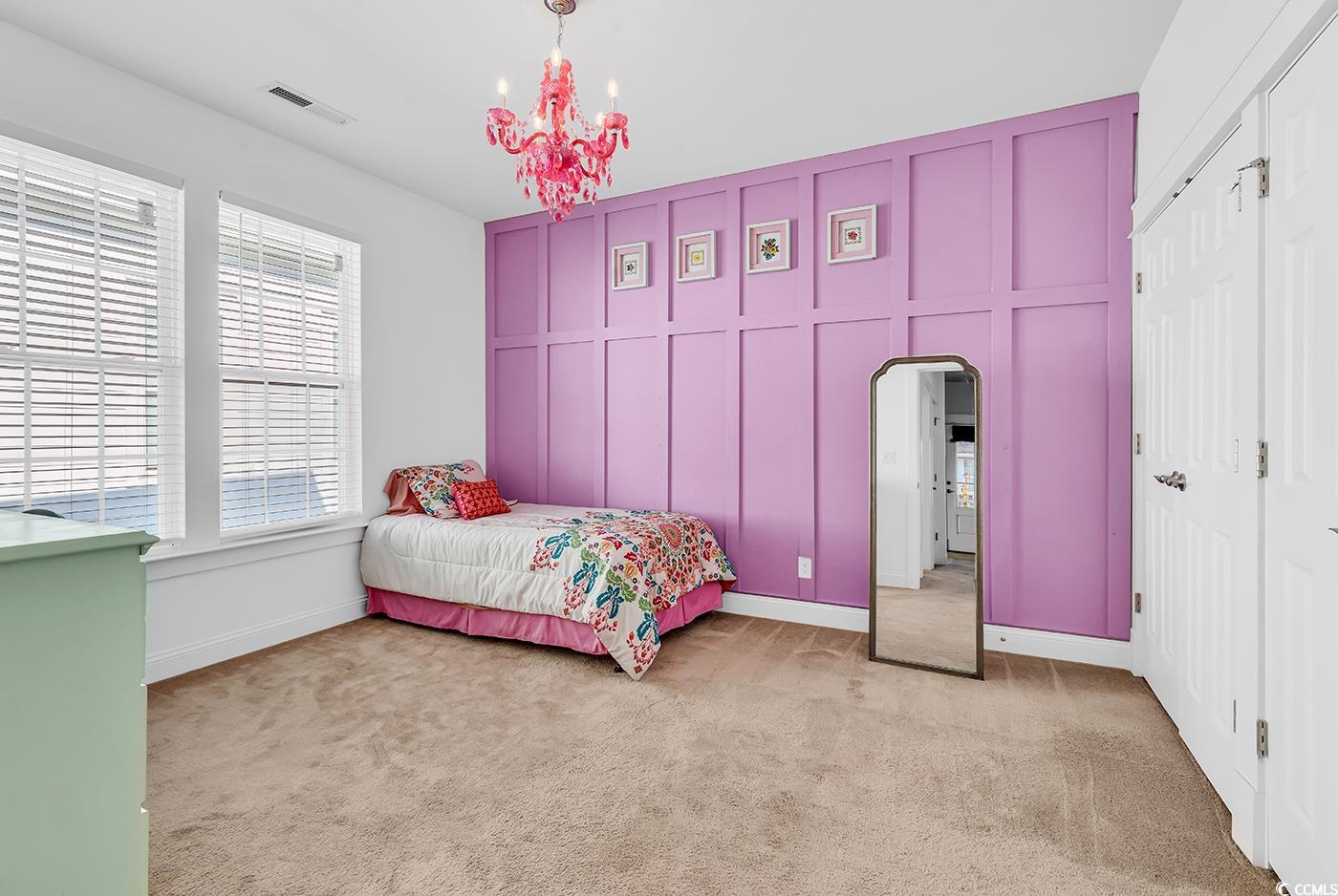 1411 Peterson Street Myrtle Beach, SC 29577 - Photo 26 of 40 Bedroom featuring light colored carpet, arched walkways, a chandelier, and a decorative wall