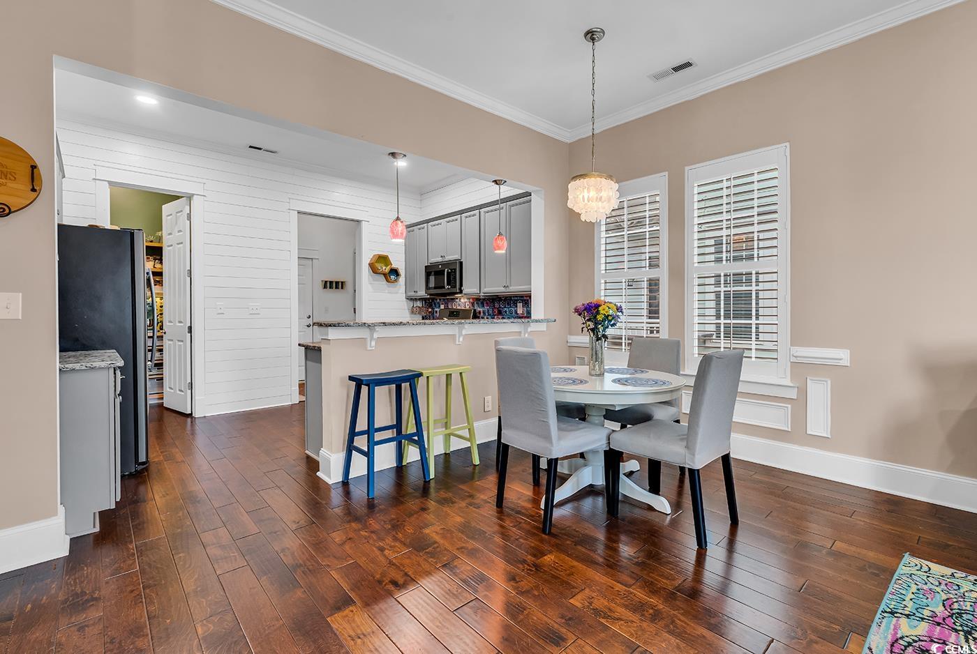 1411 Peterson Street Myrtle Beach, SC 29577 - Photo 5 of 40 Dining space with ornamental molding, dark wood finished floors, and a chandelier