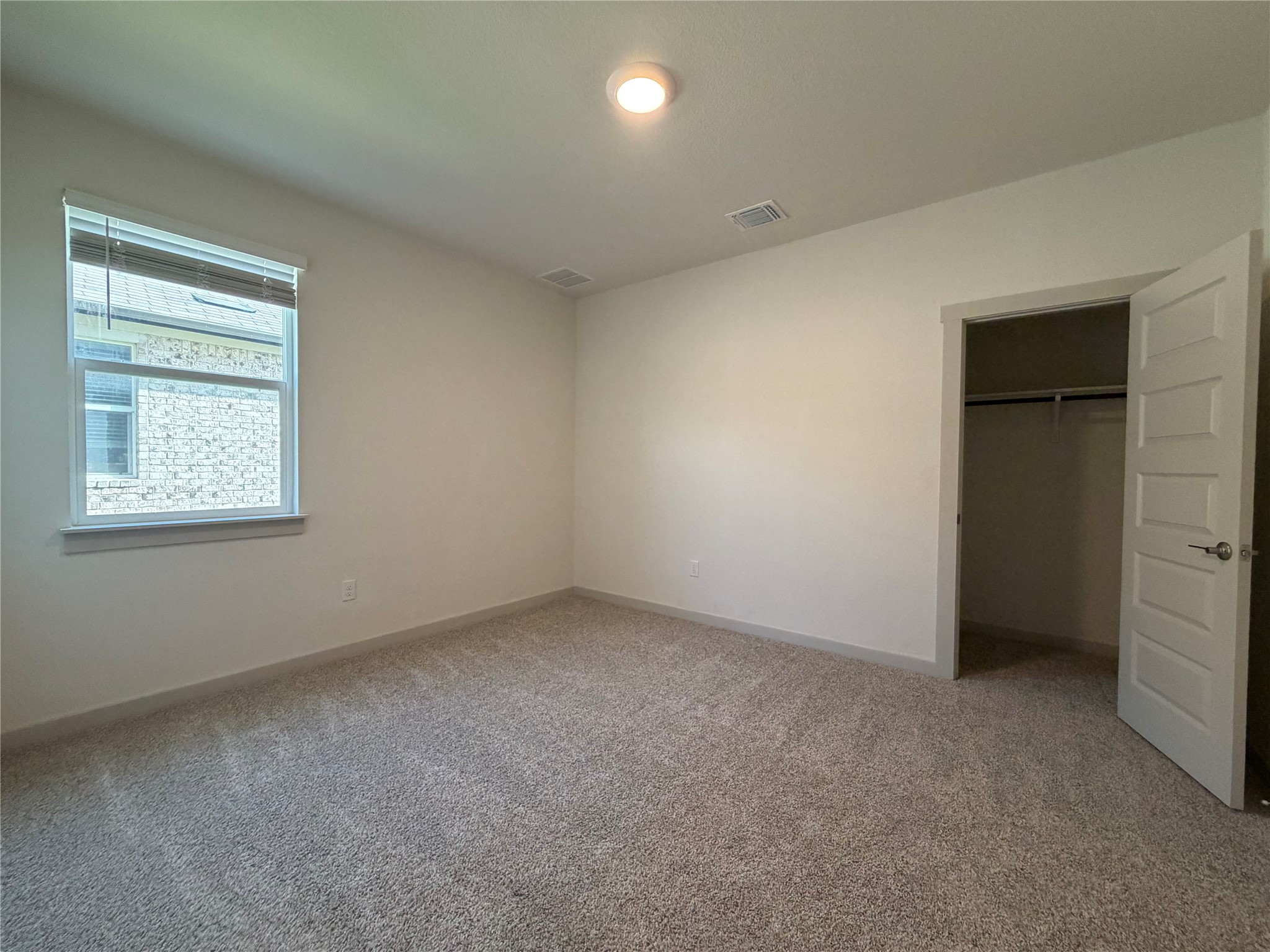 10708 Gonzales Ranger Pass Austin, TX 78754 - Photo 17 of 40 A well-lit bedroom features plush carpeting and a convenient walk-in closet.