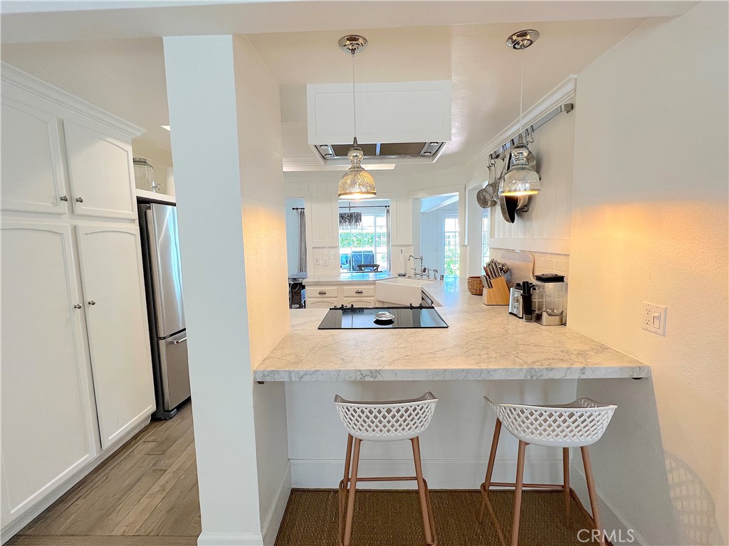 33908 Cape Cove Dana Point, CA 92629 - Photo 27 of 71 a kitchen with stainless steel appliances a table chairs and wooden floor