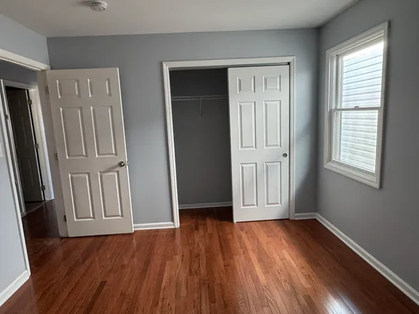 an empty room with wooden floor and closet