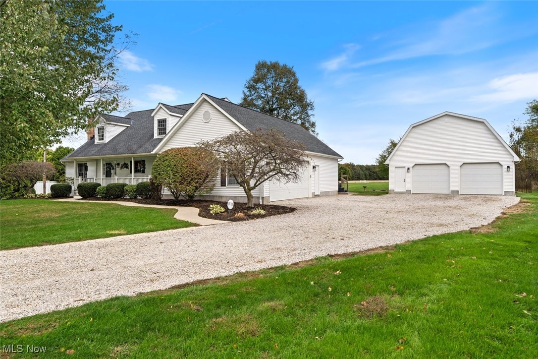 891 Station Road Valley City, OH 44280 - Photo 3 of 45 Cape cod home featuring a front yard, a porch, an outbuilding, and a garage