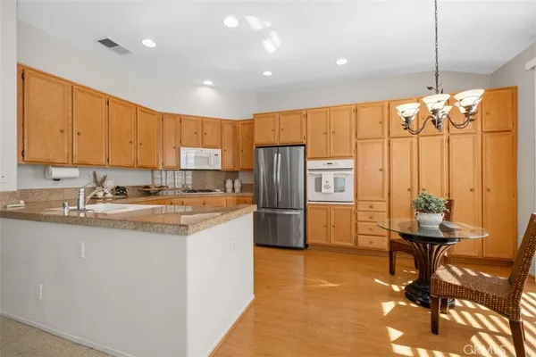 a kitchen with stainless steel appliances granite countertop a sink refrigerator and cabinets