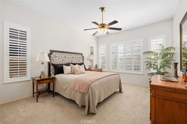 a bedroom with a bed a chandelier and a window