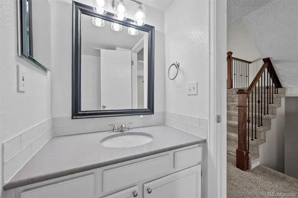 a bathroom with a sink a toilet and a mirror