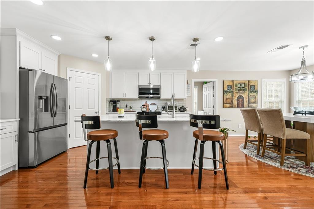 4320 Clarion Drive Conley, GA 30288 - Photo 17 of 49 a kitchen with stainless steel appliances kitchen island granite countertop a dining table chairs and a refrigerator