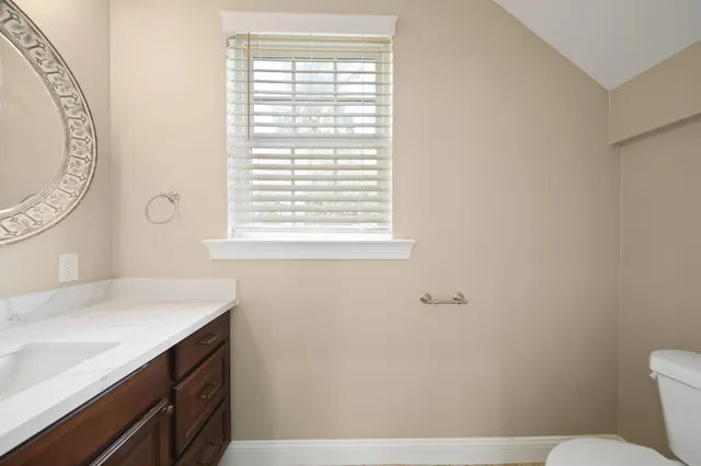 a bathroom with a sink a toilet and a window