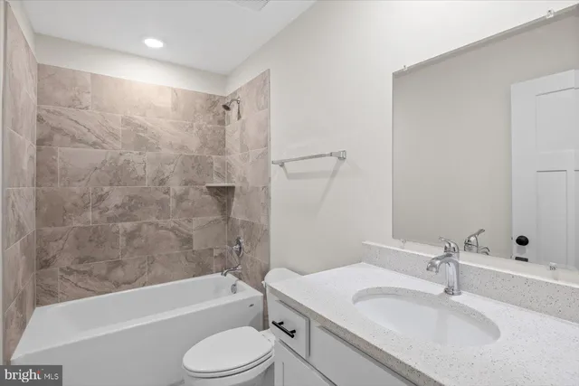a bathroom with a shower sink vanity mirror and toilet