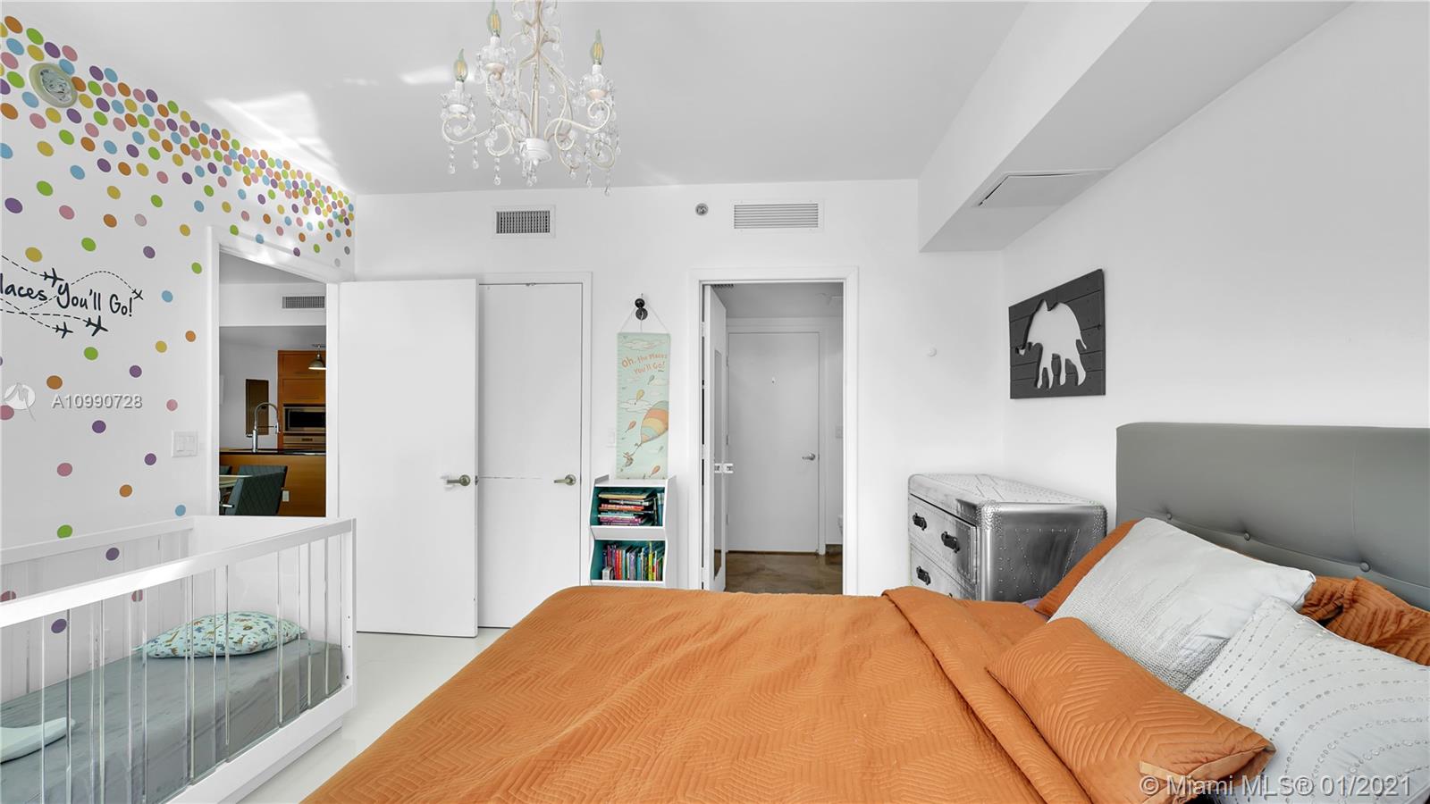 475 Brickell Avenue, Unit 5109 Miami, FL 33131 - Photo 24 of 31 a bedroom with a bed and a chandelier