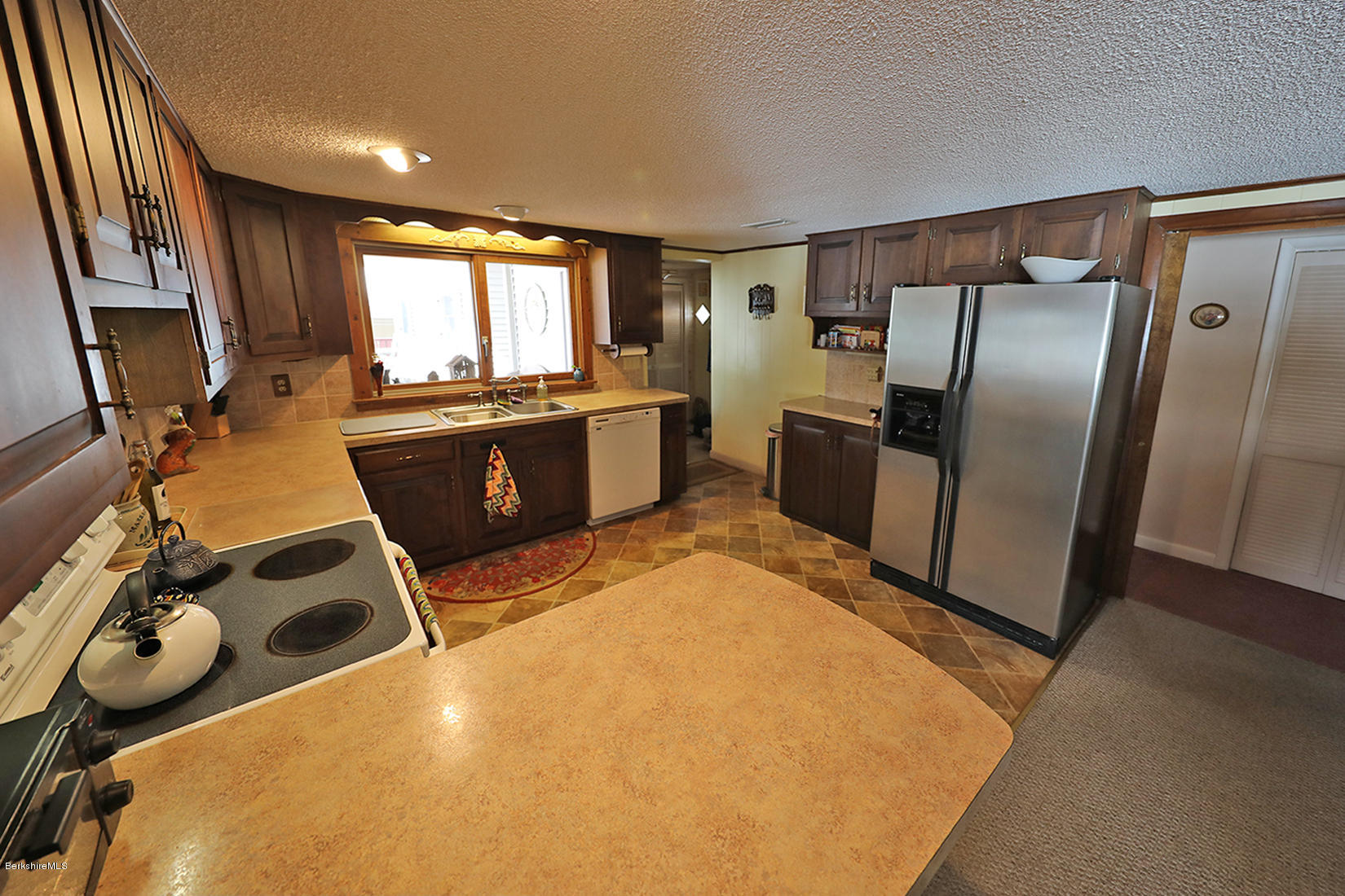 142 Kibbe Road Otis, MA 01029 - Photo 12 of 28 a kitchen with refrigerator a window and appliances