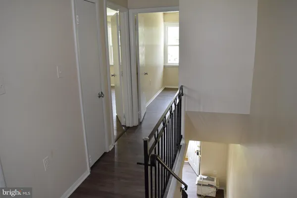 a view of a hallway with wooden floor and entryway