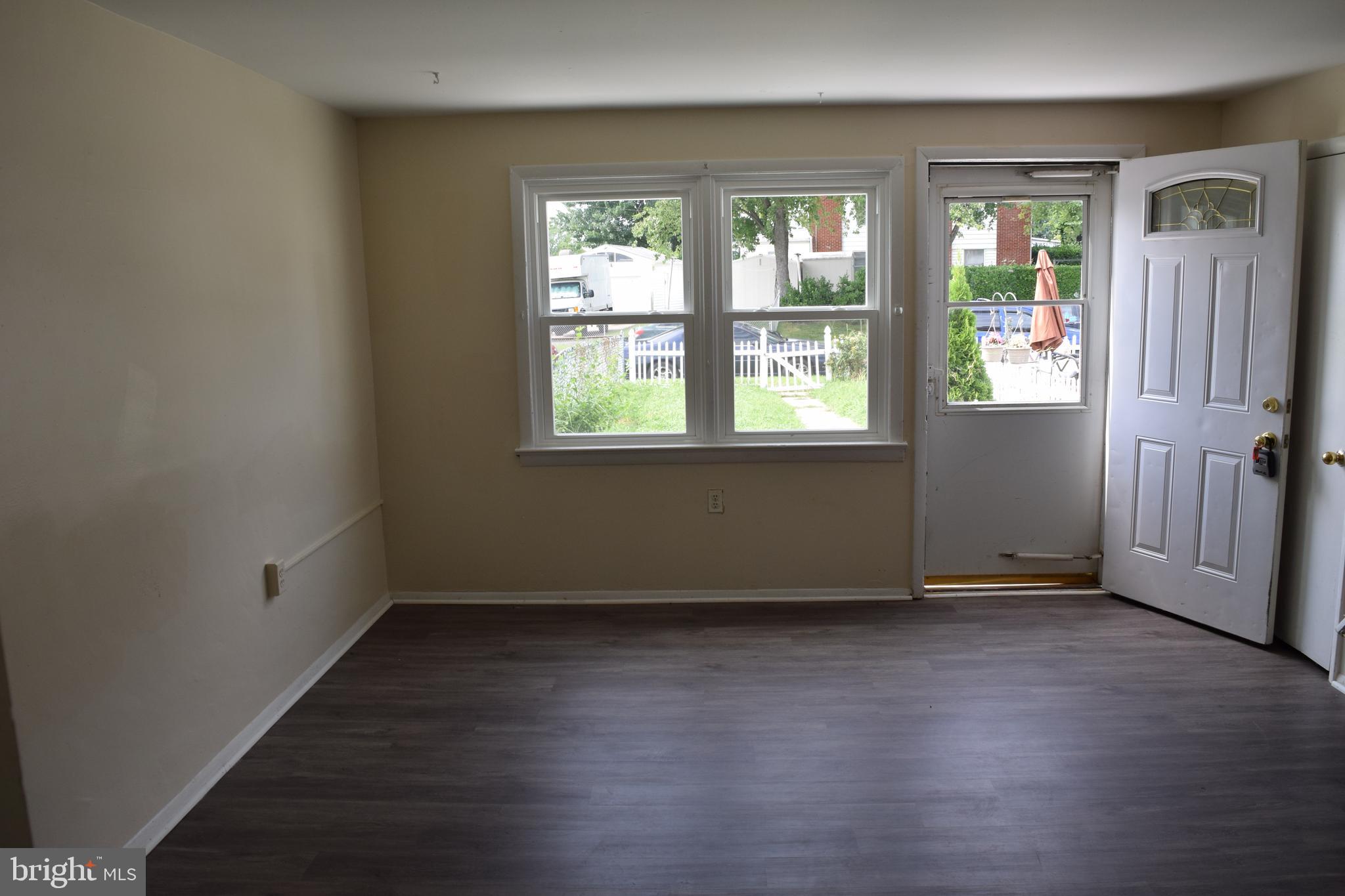 2111 Larkhall Road Baltimore, MD 21222 - Photo 6 of 13 an empty room with wooden floor and windows
