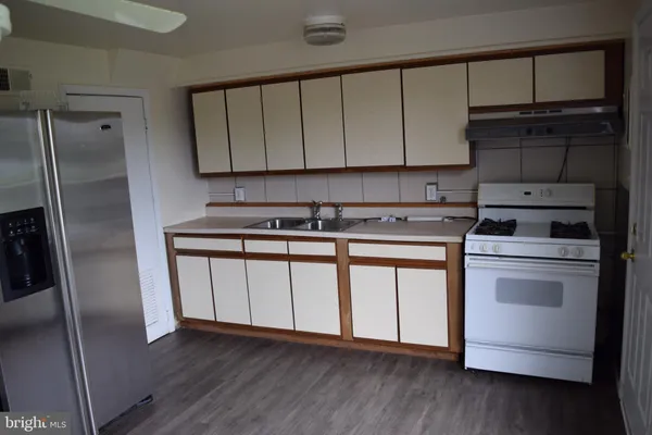 a kitchen with a refrigerator sink and cabinets